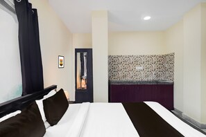 A hotel room with a bed, a bathroom, and a kitchenette. - Deluxecollection O Kothapet (Hyderabad)