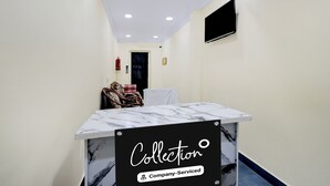 A narrow hallway with a marble table labeled 'Collection' and a flat-screen TV mounted on the wall. - Deluxecollection O Kothapet Near Omini Hospital (Hyderabad)