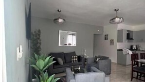 Een woonkamer met een bank, een salontafel en een potplant.