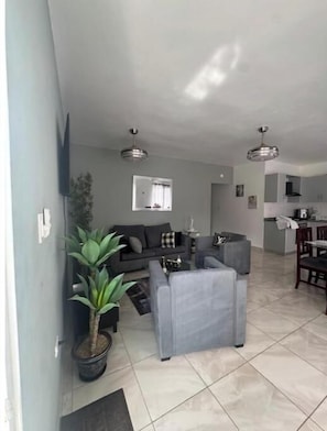A living room with a sofa, a coffee table, and a potted plant. - Nice two-bedroom apartment (Sosúa)