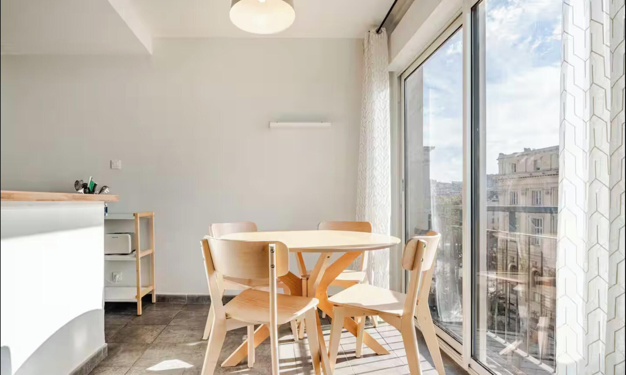 Een moderne keuken met een eetgedeelte, grote ramen en uitzicht over de stad.