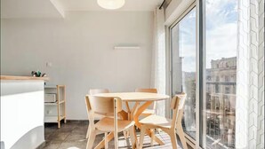 Een moderne keuken met een eetgedeelte, grote ramen en uitzicht over de stad.