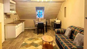 A compact living space with a kitchenette, a dining area, and a sofa. - Gemutliche Wohnung in Konz an der Mosel (Konz)