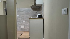 Une cuisine compacte dotée d’une cuisinière intégrée, d’un évier et d’un petit plan de travail.