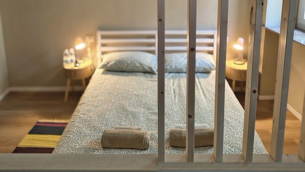 Une chambre avec un lit superposé, une table de chevet avec une lampe et un petit bureau avec une chaise.