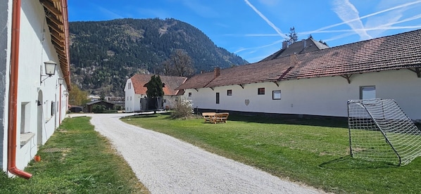 A building with a gravel path, a wooden bench, and a soccer goal.