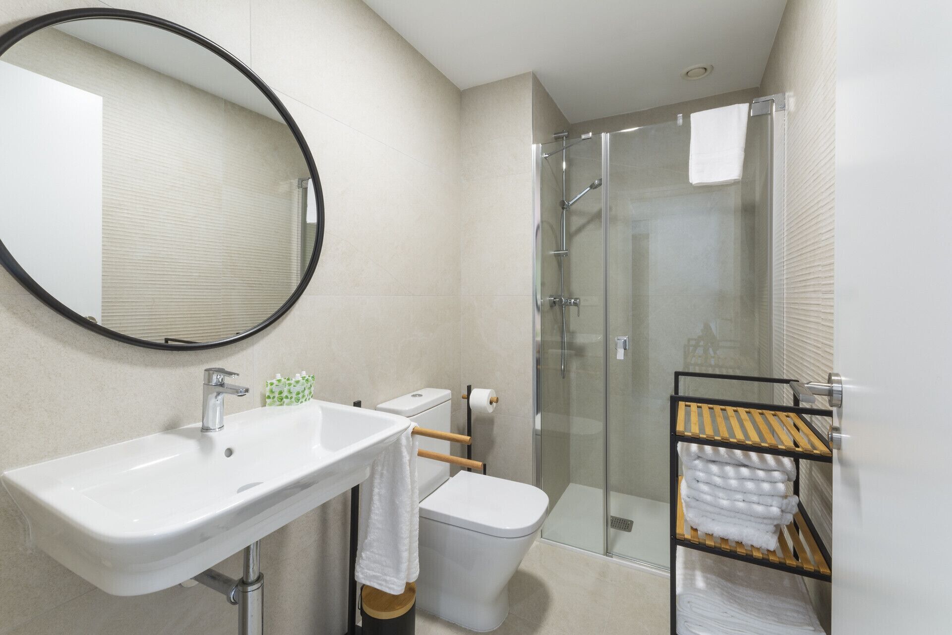 A modern bathroom with a sink, toilet, and glass shower enclosure.