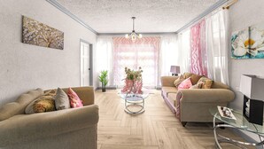 En stue med to sofaer, et glasbord og en loftlampe.