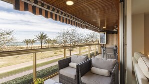 A balcony with wicker furniture, a view of the beach, and a wooden ceiling. - Luxury vacations in Bermuda Apartments in front of the beach - ONLY FAMILIES (Playa de Gandía)