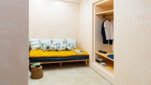 Un dormitorio pequeño con cama, armario y mesita de noche.