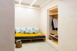Una camera piccola con un letto, un armadio e un comodino.