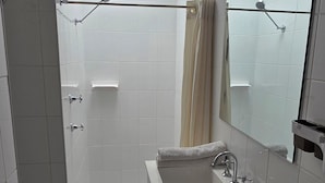 A bathroom with a shower, sink, and mirror. - Sisleys Motel (Lismore)