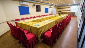 A conference room with a long table, red chairs, and a projector screen. - Hotel Holiday Regency  (Kathmandu)