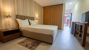A bedroom with a bed, bedside tables, a TV, and a wardrobe. - Viana Hotel (Viana)
