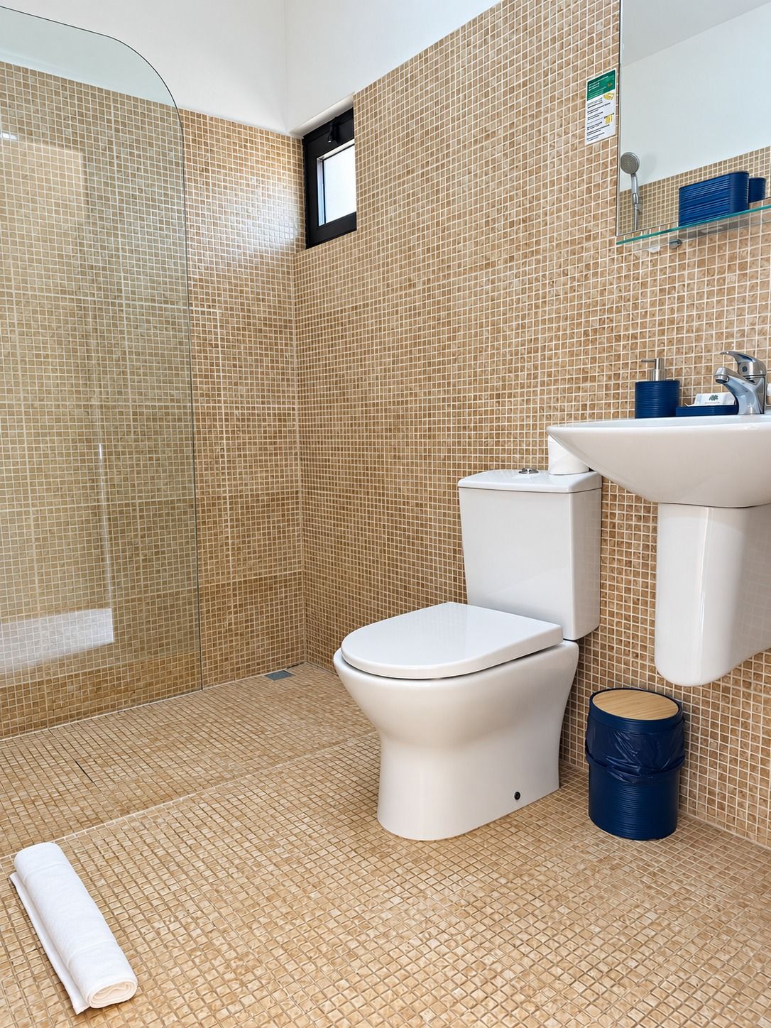 A bathroom with a toilet, sink, and shower area.