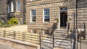 A historic building with a stone facade, numbered 6, featuring a grand entrance with steps and a wrought iron gate. - Stuart Suite (Edinburgh)