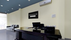 A reception desk with a sign that reads 'TOWNHOUSE Company-Serviced.' - Deluxehotel Chakripuram (Hyderabad)