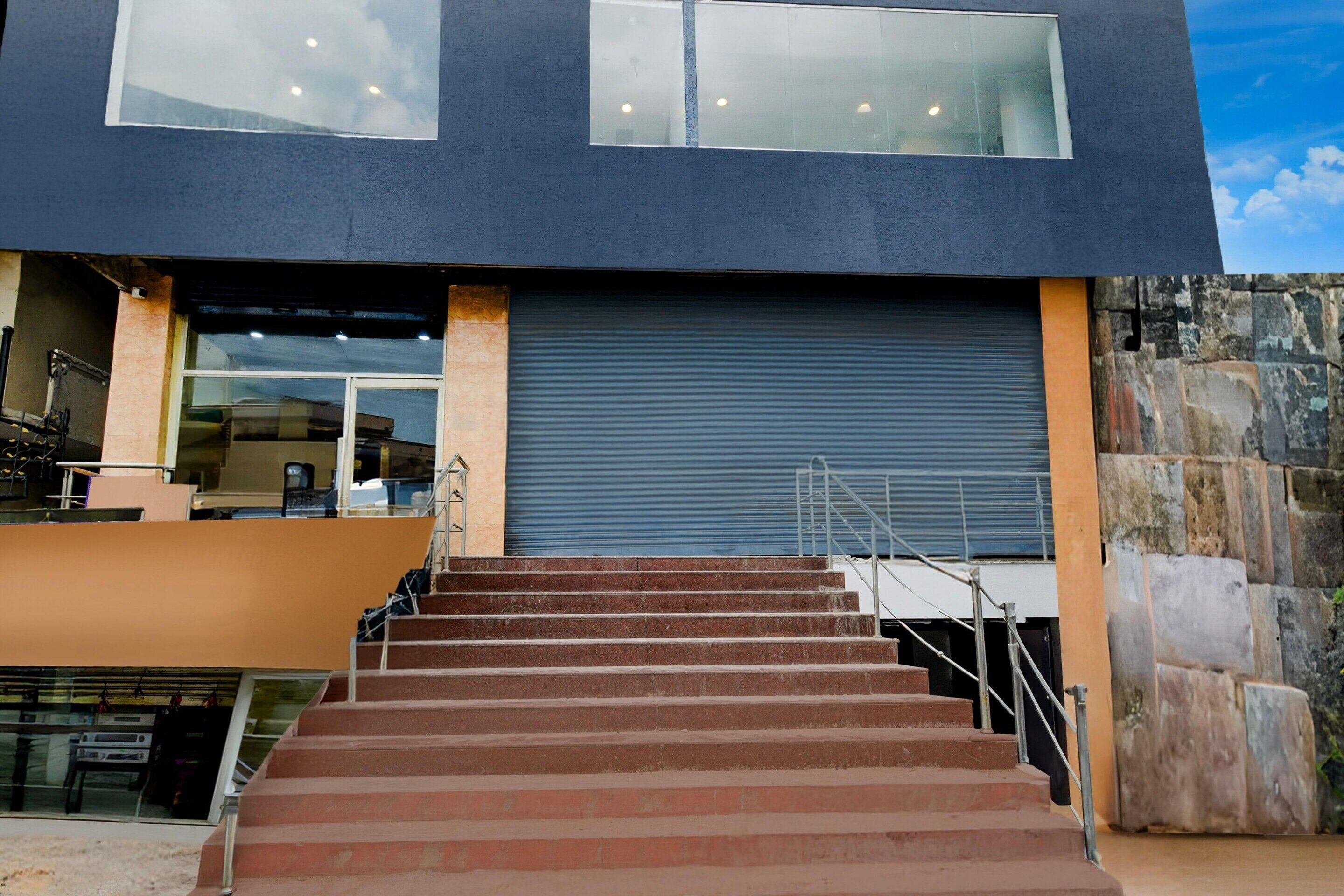 A modern building with a set of stairs leading to a large garage door.