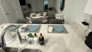Una cocina moderna con un lavamanos, grifo y un organizador transparente con utensilios.