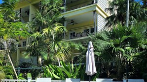 A hotel with a pool, lounge chairs, and palm trees. - Indigo @Serendip Vacation Condos (Cruz Bay)