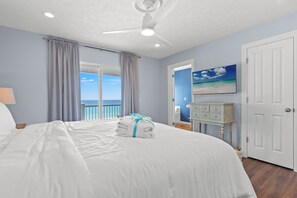 A bedroom with a bed, a ceiling fan, a view of the ocean, and a door. - Beachfront Luxury! 4BR Townhouse W/pool & Stunning Gulf Views! Sleeps 10! (Panama City Beach)