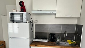 Eine kompakte Küche mit Mikrowelle, Toaster, Wasserkocher und Spüle.