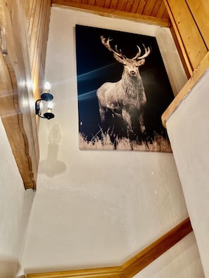 A room with a wooden ceiling, a white wall, and a framed picture of a deer. - Chalet, terrace, fireplace or stove, parking, 145m², Les Gets (Les Gets)