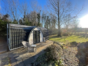 A small, single-story structure with a sloped roof, a door, and a window.