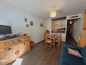 A compact living space with a television, wooden furniture, a dining area, and a kitchenette. - 300m from ski slopes, 1st floor, balcony, parking, tv, ski locker, 36m², Les 2 Alpes (Les Deux Alpes)