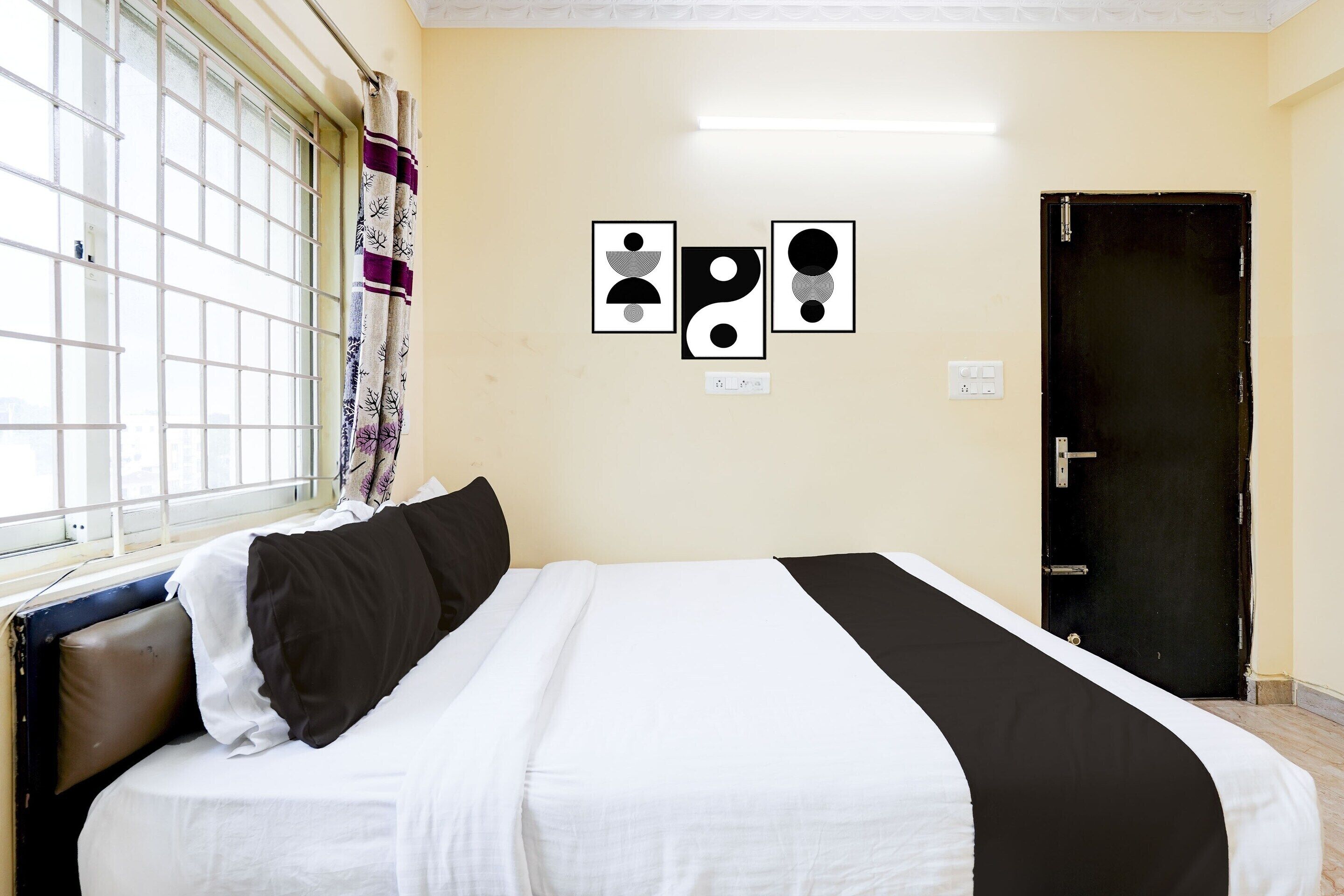 Een kamer met een bed, een raam met tralies en een deur.