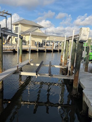 A marina with docked boats, a covered boat ramp, and a building with a sloped roof. - Ideal Tarpon Fishing condo with dock slip in Placida Florida! (Placida)