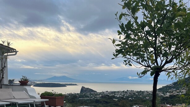 Una piscina con vista a una ciudad lejana y montañas.