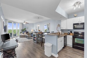 A spacious kitchen with a large island, a dining area, and a view of the outdoors. - 2610 Gorgeous Sunset Views ~ Book Aug 8th, Fireworks ~ Pools & Resort Bar (Destin)