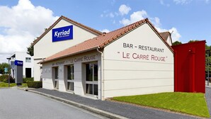 Un edificio con un cartel que indica 'Kyriad Hotel Restaurant' y el bar 'Le Carré Rouge'.