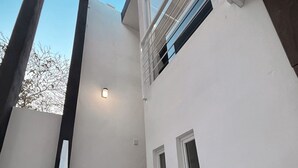 Portaat, jotka johtavat toisen kerroksen parvekkeelle, jolta on näkymä taivaalle.