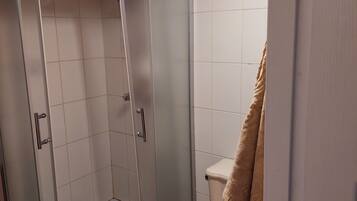 Chuveiro, toalhas de banho, sabonete, shampoo