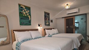 Une chambre d’hôtel avec deux lits, un grand miroir, des œuvres d’art murales, un appareil de climatisation et une porte donnant accès à la salle de bain.