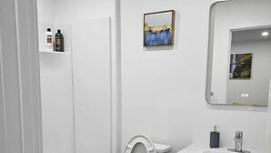 Ett modernt badrum med badkar, toalett och handfat.