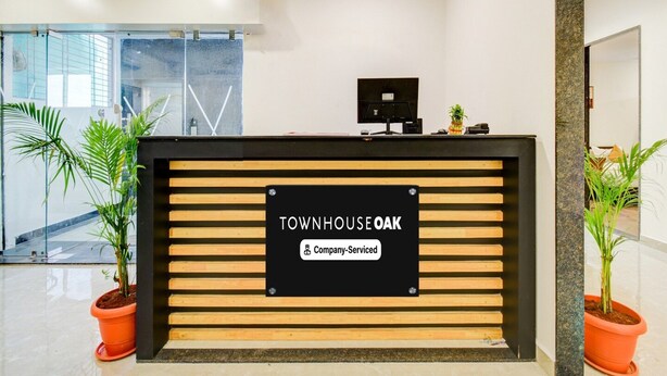 A reception desk with a sign reading 'TOWNHOUSE OAK' and 'Company-Served.' - Deluxe Tolkanti Arc (Hyderabad)