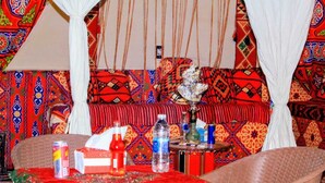 A room with a patterned sofa, a table with a red cloth, and a decorative item on the table. - Pyramids Essence hotel (Giza)