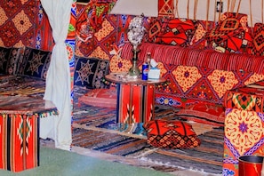 A room with patterned carpets, a sofa, a table with a hookah, and a Pepsi can. - Pyramids Essence hotel (Giza)