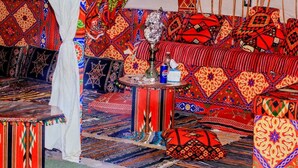 A room with patterned carpets, a sofa, a table with a hookah, and a Pepsi can. - Pyramids Essence hotel (Giza)