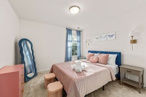 Ein Schlafzimmer mit Bett, Nachttischen, Kommode und Spiegel.
