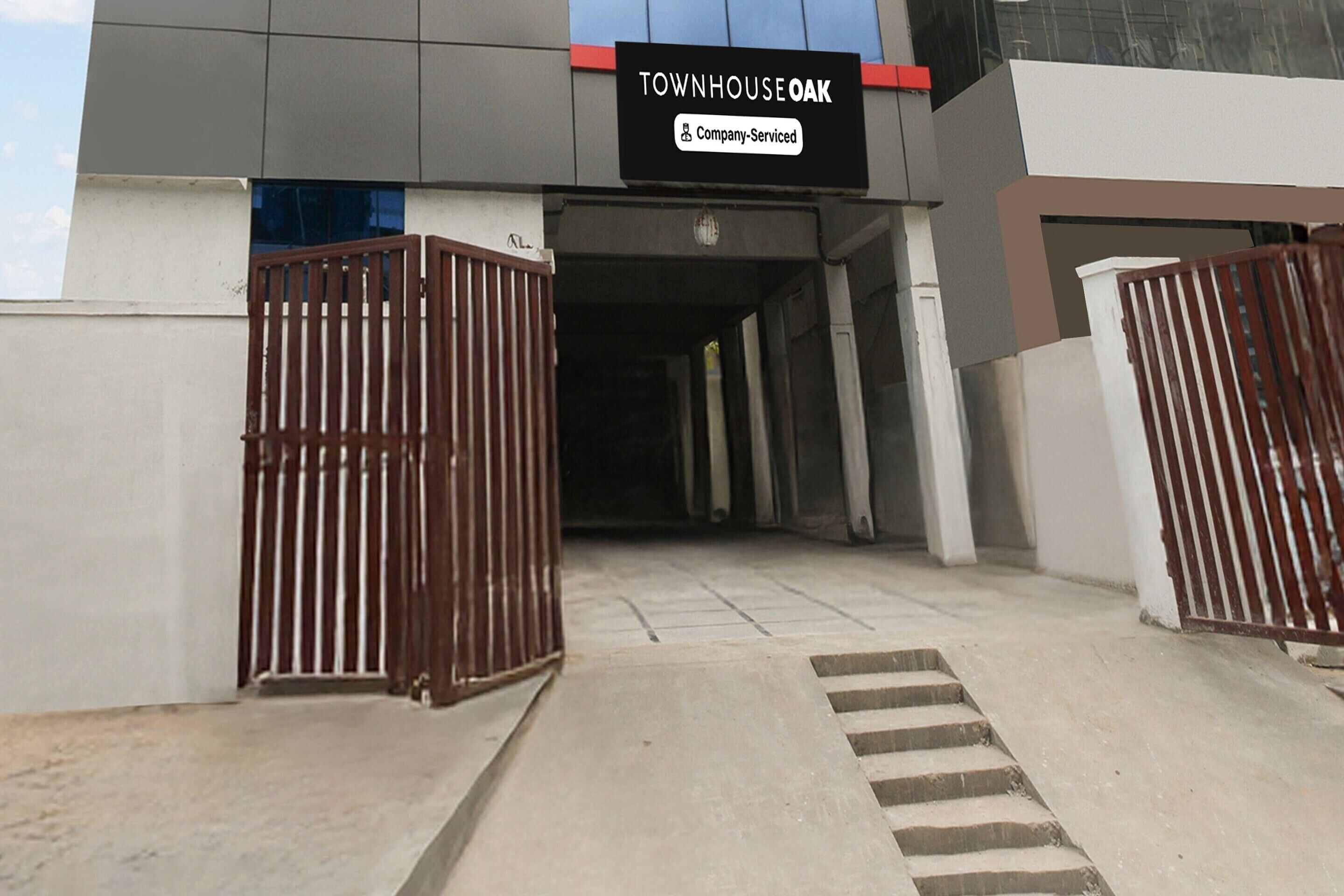 Entrada de un edificio con un letrero que dice 'TOWNHOUSE OAK Company Serviced'.
