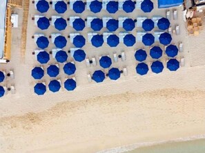 A beach with rows of blue umbrellas and white lounge chairs. - Luxury 2 bed 2 bath with optional pull out. In the heart of Cabo San Lucas. (Cabo San Lucs)