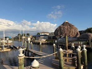 A marina with boats docked, wooden piers, and thatched-roof structures. - Villa Blue Water - Cape Coral (Cape Coral)