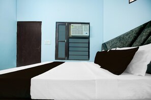 A room with a bed, a door, and an air conditioning unit.