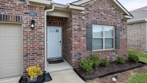 A brick house with a garage door, a front door, and a mailbox.