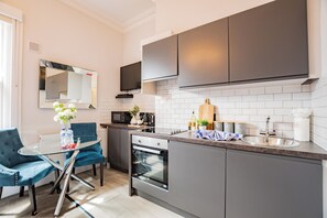 Una cocina moderna con comedor, electrodomésticos integrados y televisor de pantalla plana.