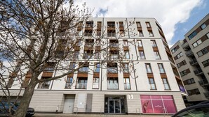 Een meerlaags gebouw met een modern architectonisch ontwerp, met een gelijkvloerse ingang met glazen deur en het getal '3' op de gevel.